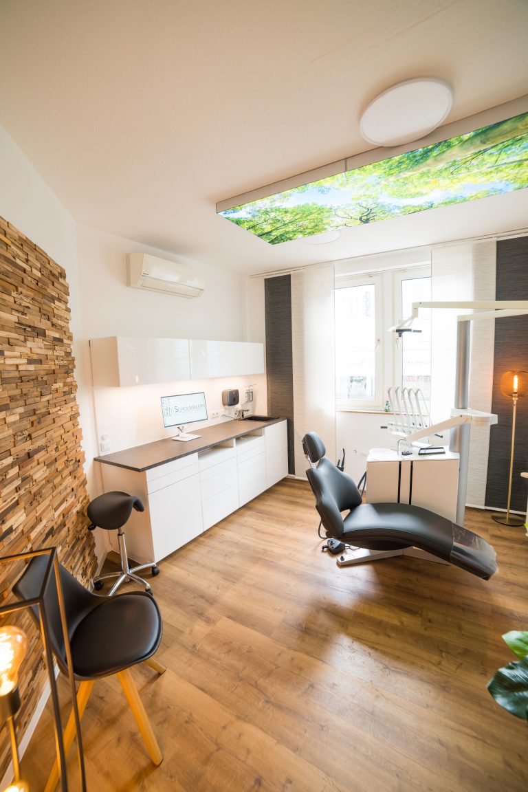 Behandlungszimmer mit Holzwand, Tageslicht und Deckenbild